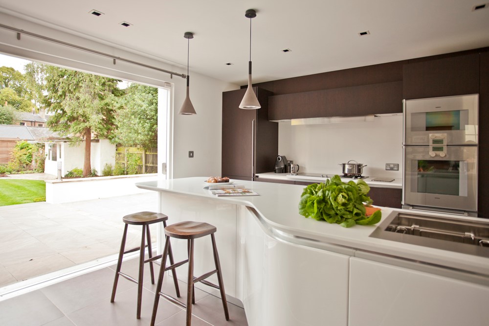 cucina evoluzione di effeti dalle linee sinuose con isola e vista su una porta finestra che illumina la stanza